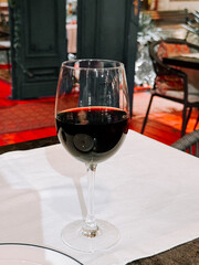 Elegant red wine glass on table in a restaurant ambiance with warm lighting