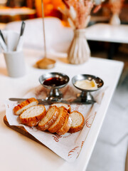 Freshly sliced bread served with jam and butter on a stylish table in a cozy cafe