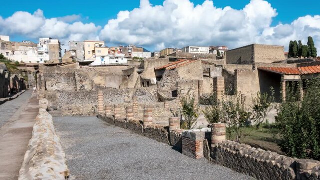 Timelapse of visitors walking through the narrow ancient streets of Herculaneum, the Roman city destroyed by the eruption of Mount Vesuvius in 79 AD. Naples, Italy.