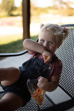 Giggling toddler with bag of candy corn
