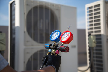 Electrical technician use manifold gauge check and filling refrigerant vacuum pump evacuates industry air conditioning HAVC system maintenance or chiller and air conditioner cleaning filter service.