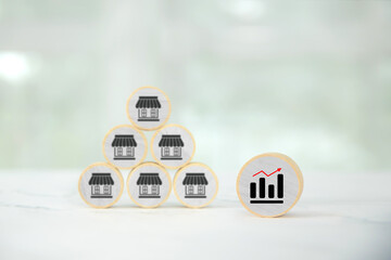 Wooden toy stack with graph and franchise business store for franchising to growth branch expansion and business banking loan or consumer resources service.