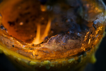 Close up the warm glow of a burning candle melted wax textures and flickering flame details 