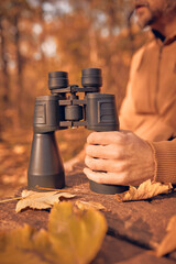 Fototapeta premium Amateur birdwatcher observing birds and other animals in nature with binoculars.
