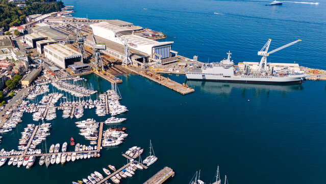 Aerial view of the Fincantieri Shipyard in Castellammare di Stabia, an important industrial hub for shipbuilding, with the port, docks, and the Gulf of Naples in the background. Italy.