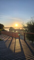 Fototapeta premium Golden sunset at Lago Ranco in southern Chile, with calm waters, mountains, and warm evening light creating a serene and picturesque landscape.