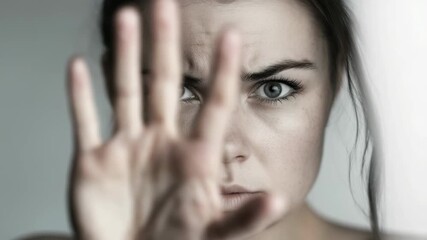 A woman raises her hand in a gesture to stop the violence. Support efforts to prevent domestic assault and address women's vulnerability. This is a video to stop outrage