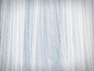 Obraz premium Beautiful winter background with snowy ground. Natural snow texture. Wind sculpted patterns on snow surface.