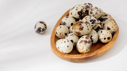 Obraz premium Quail eggs nestle in rustic wooden bowl, embodying fertility and rebirth during Hanami and World Egg Day celebrations