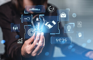 Businesswoman holding bulb with futuristic B2B icons and digital data graphics overlay.