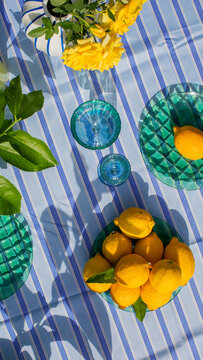 Sunlit citrus splendor on vibrant table, lemon zest for midsummer picnic, evoke Santosh celebrations, vibrancy in blue and yellow