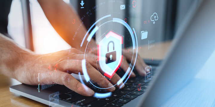 Cybersecurity data protection concept with digital padlock interface hovering over hands using laptop on wooden desk in office environment.