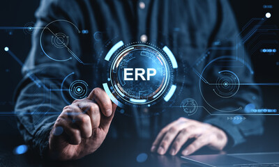 ERP system integration concept with businessman interacting with digital interface and futuristic tech graphics on virtual screen in dark environment.