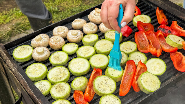 Grilling vibrant zucchini and mushrooms, summer solstice feast, vibrant vegetarian BBQ, European male hand, culinary celebration