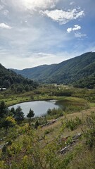 Peaceful view of Laguna San Jorge near Puc&oacute;n, Chile, with calm water, sandy beach, and forested hills under a cloudy sky.