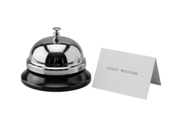 Highly polished chrome service bell with a dark matte base and a crisp white guest welcome card on a seamless transparent studio background, 45-degree elevated view, high-end product presentation