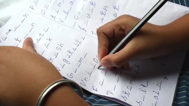 child engaged in making a word puzzle with missing letters on paper during free time while traveling. improves vocabulary, spelling, and problem-solving skills in a fun and educational way