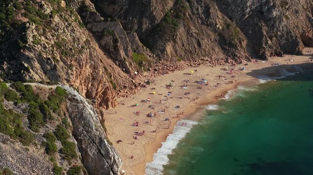 Praia da Ursa beach, Portugal, washed by waters of Atlantic Ocean. This is one of most beautiful and wild beaches. People enjoying sea, dramatic rock formations, and breathtaking coastal views.	