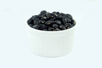 Black beans in a bowl on a white background.