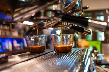 Close up of espresso shot from a professional coffee machine at coffee shop.