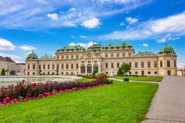 Obraz premium Historic Belvedere palace in Vienna with reflection in the water, green garden and blue sky.