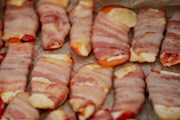 Raw bacon wrapped chicken pieces laid on tray ready for oven cooking, flavorful homemade dish prepared for barbecue, festive dinner, party appetizers and family style meals