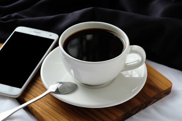 Hot Black Coffee with Smartphone and Spoon for Modern Lifestyle