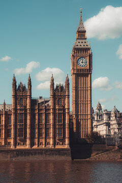 Majestic big ben clock tower against blue sky and white clouds, a symbol of london and england