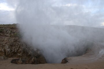 agua del mar emergiendo por agujeros de la tierra creando una nube de agua