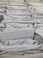 Fototapeta premium Stacks of Light Blue Fabric in Soft Folds Creating an Abstract Pattern