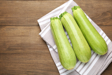 Fresh ripe zucchinis on wooden table, top view. Space for text