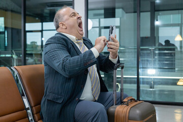 Senior reading documents at airport gate