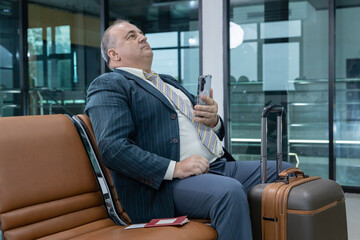 Senior reading documents at airport gate