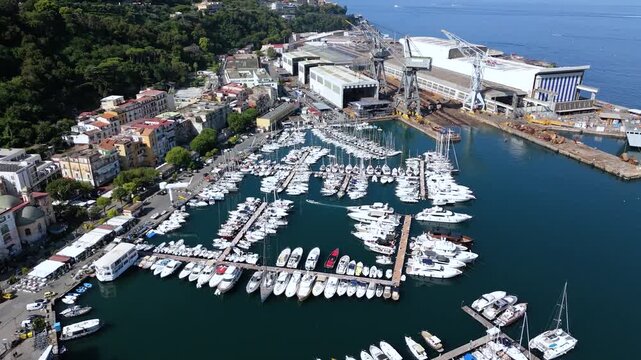 Aerial view of the Fincantieri Shipyard in Castellammare di Stabia, an important industrial hub for shipbuilding, with the port, docks, and the Gulf of Naples in the background. Italy.