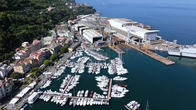 Aerial view of the Fincantieri Shipyard in Castellammare di Stabia, an important industrial hub for shipbuilding, with the port, docks, and the Gulf of Naples in the background. Italy.