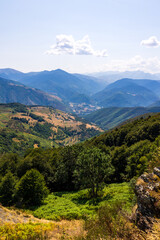 Naklejka premium Panoramic view of the lush Aure Valley from the Col d’Aspin, with the Pyrenean peaks forming the horizon