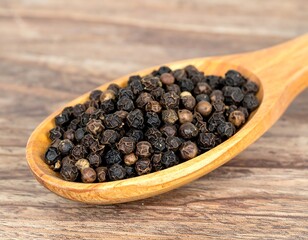 Peppercorns in wooden spoon on wood table