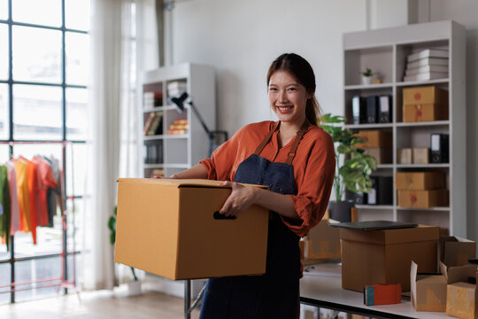 Startup SME small business entrepreneur SME of freelance Asian woman packaging box on her hand lifts up online marketing and delivery SME idea concept
