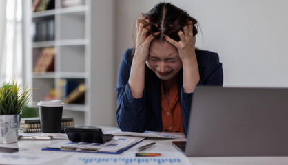 Asian woman working on laptop having a headache stress and eye strain Tired, sad unhappy tired...