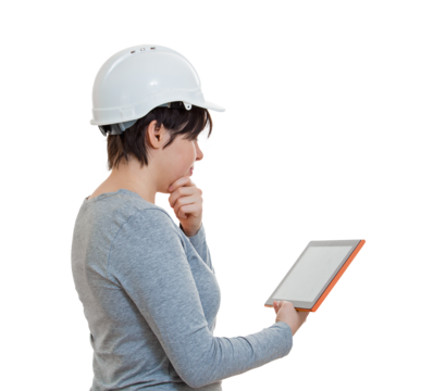 Side view pensive woman engineer wearing protective white helmet, looks focused as uses the tablet gadget during work. Solving problems with the help of modern technology