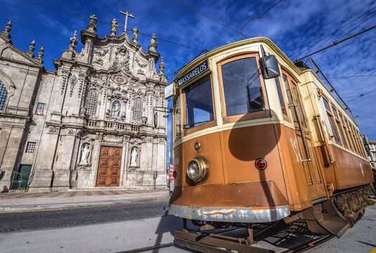 Porto, Portugal - December 8, 2016: Vintage tourist tramway in front of famous twin churches - Carmelite Church and Carmo Church in Porto
