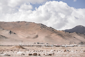 Highland village of Karakol against the backdrop of rocky mountain ridges in the Pamirs in the Tien Shan Mountains