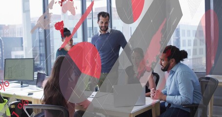 Five team members reviewing digital charts and leaning over desk in office meeting, with laptops