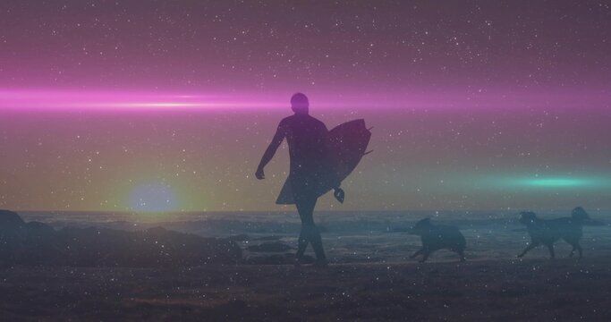 Walking silhouette man in wetsuit carrying surfboard on sunset beach, with two dogs running on sand - Powered by Adobe