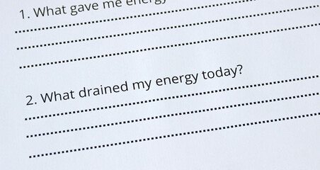 Extreme close-up of a question on a sheet of paper 'What drained my energy today?'. Self-reflection question, therapy, psychology, self-awareness, mindfulness concept, journaling