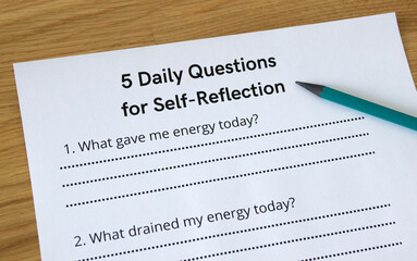 Close-up of a sheet of paper titled '5 Daily Questions for Self-Reflection' with a pencil pointing to the title. Self-awareness and self-reflection concept, questions, therapy, psychology