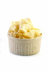 Tofu sheets in a cup placed on a white background.