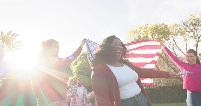Friends walking triggered by arm raise draping American flag for marketing campaign while cheering