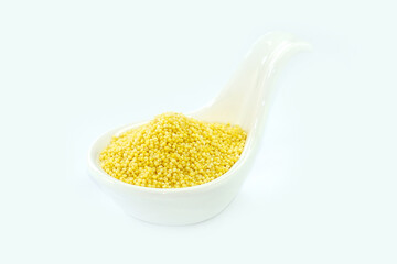 Millet in a White spoon-shaped cup on a white background.