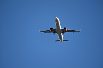 Passenger airplane in blue sky seen from below
